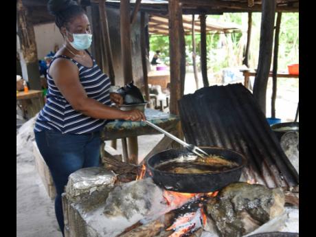 Michelle Fritz prepared fish for her customers in Scotts Cove, which sits on border of St Elizabeth and Westmoreland last Friday. She said that with the easing of the curfews, this is now their Easter as sales are gradually improving.