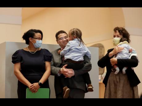 Renatha Francis (left) smiles as she and her family are introduced during a news conference on Tuesday at the Miami-Dade Public Library in Miami. Francis, a Palm Beach County circuit judge who immigrated from Jamaica, share the moment with her husband Phillip Fender (centre), holding their son Joshua, Francis’ mother, Hyacinth, holding their son Matthew.