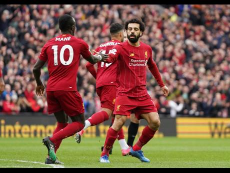 Liverpool's Mohamed Salah (right) celebrates with teammate Sadio Mane after scoring his side's opening goal during the English Premier League match against Bournemouth at Anfield Stadium in Liverpool, England, on Saturday, March 7. 