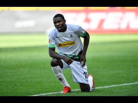 Moenchengladbach’s Marcus Thuram gets up after taking the knee after scoring his side’s second goal during the German Bundesliga match between Borussia Moenchengladbach and Union Berlin in Moenchengladbach, Germany, Sunday, May 31, 2020. 