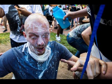 Milk is poured into a demonstrator’s eyes to neutralise the effect of pepper spray during a rally at Lafayette Park near the White House in Washington.