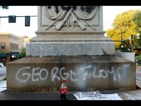 In this May 31, 2020 photo, protesters vandalise the  Athens Confederate War Memorial after the main protest ended in downtown Athens, Georgia. 