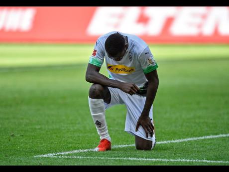 Moenchengladbach’s Marcus Thuram taking the knee after scoring his side’s second goal during the German Bundesliga soccer match against Union Berlin in Moenchengladbach, Germany, on Sunday, May 31.