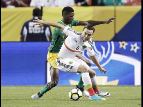 National defender Damion Lowe (left) battles Mexico’s Erick Torres during a Concacaf Gold Cup match in Denver, Colorado, on Thursday, July 13, 2017. The game ended in a 0-0 draw.