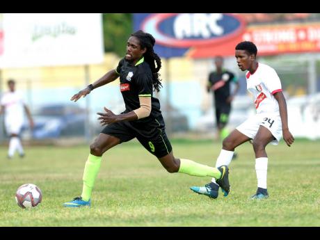 Tajahe Dixon (left) of Molynes United FC beats Arnett Gardens’ Damari Deacon to a loose ball during their RSPL encounter at the Waterhouse Mini Stadium on Sunday, September 22, 2019.