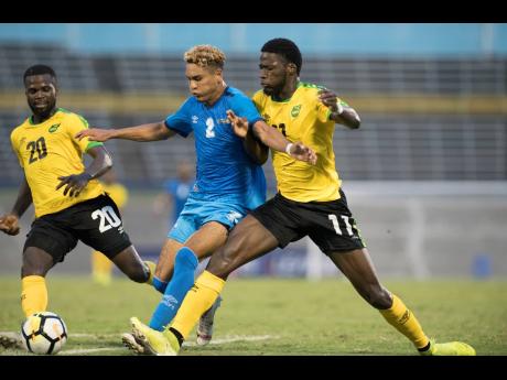 Shamar Nicholson (right) and teammate Kemar Lawrence battle for possession of the ball against Aruba’s Glenbert Croes (centre) during a game in the Concacaf Nations League at the National Stadium in Kingston on Saturday, October 12, 2019.