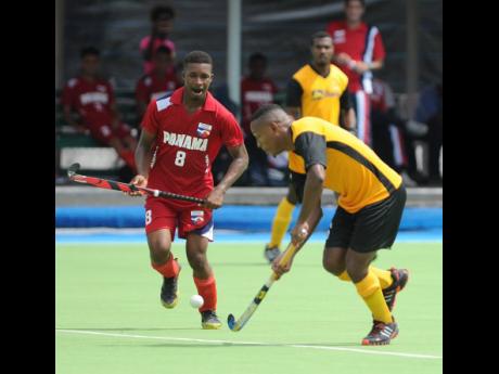 Jamaica’s Nicholas Beach dribbles by  Panama’s  Angelo Boodie in the Central American and Caribbean Games qualifier at the Mona hockey field on November 5, 2017.