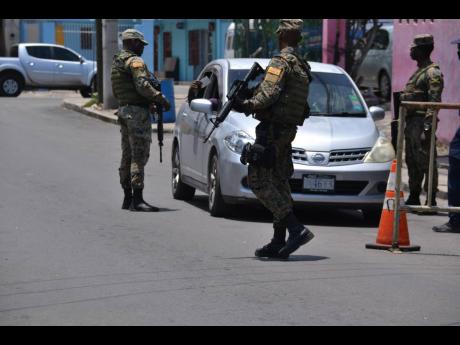 Security forces man a checkpoint along West Avenue in Greenwich Town yesterday.