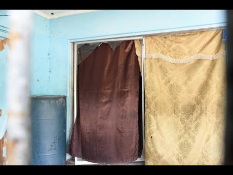 Credit: Kenyon Hemans Makeshift curtains are used to cover glass doors of a St Andrew house where residents say gay sex workers operate a brothel.