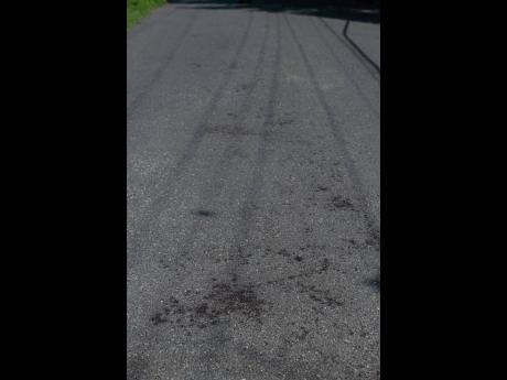 Bloodstains and footprints were visible along Lawrence Drive in St Andrew yesterday after a man was stabbed the previous night.