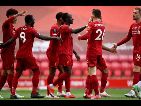 Liverpool’s Sadio Mane (centre) celebrates after scoring the opening goal during the English Premier League match between Liverpool and Aston Villa at Anfield Stadium in Liverpool, England, Sunday, July 5, 2020. 