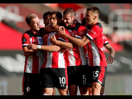 Southampton’s Che Adams (second left) is congratulated by teammates after scoring his team’s first goal during the English Premier League soccer match between Southampton and Manchester City at St Mary’s Stadium in Southampton, England, Sunday, July 5, 2020. 