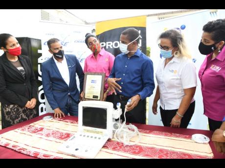 Chief Medical Officer at the Sir John Golding Rehabilitation Centre, Dr Rory Dixon (third right), explains the use of the portable ultrasound machine to  (from left) Latoya Aquart-Foster, CHASE project manager; Johann Heaven, CEO, Proven Wealth; Kecia Taylor, past services director, Rotary Club of St Andrew North; Lori Chuck, past president, Rotary Club of St Andrew North; and Denise Harris, chief marketing officer, C&WJ Credit Union, at the presentation of the equipment to the centre on July 3.