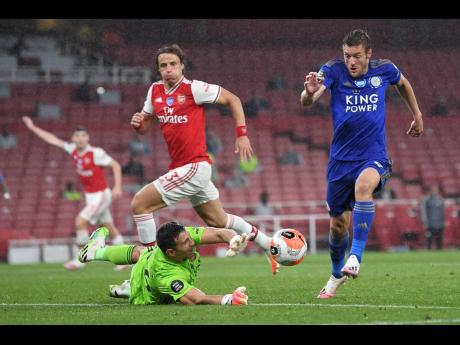 Leicester’s Jamie Vardy attempts to take the ball past Arsenal’s goalkeeper Emiliano Martinez during the English Premier League match between Arsenal and Leicester at Emirates Stadium in London, England, Tuesday, July 7, 2020. 