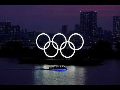 In this June 3, 2020 photo, the Olympic rings float in the water at sunset in the Odaiba section in Tokyo. 