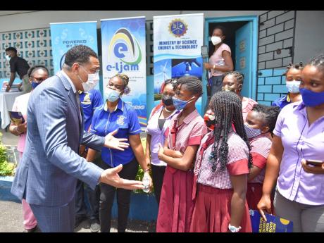 Prime Minister Andrew Holness  speaks with students and teachers at Balcombe Drive Primary School in St Andrew last Thursday, after handing over tablets to  teachers at the institution.