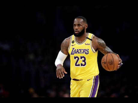 In this March 10, 2020 file photo, Los Angeles Lakers’ LeBron James (23) dribbles during the first half of an NBA basketball game against the Brooklyn Nets in Los Angeles.  