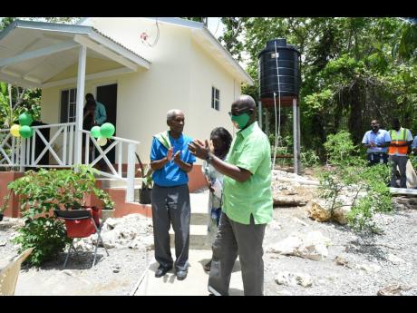  Minister of Local Government and Community Development Desmond McKenzie (right) celebrates with beneficiaries of an indigent house – (from left) Everald Gibson and his wife, Hazel – at the handover ceremony held on July 10 in Long Road, Portland.