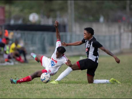 Ronaldo Webster of Cavalier FC tackles UWI FC’s Nacquain Brown (left) in their Red Stripe Premier League Fixture played at the UWI Mona Bowl on Sunday February 23.