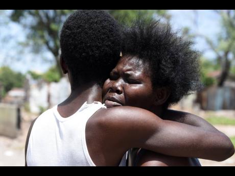 Credit: Kenyon Hemans Lilieth Walters is consoled by a friend after she broke down in tears on hearing that her son Chavane Austin had been killed.