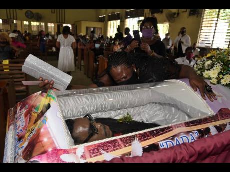 Nickesha Palmer, sister of Irvino English, cries uncontrollably as she views the body of her brother yesterday at the Penwood Seventh-day Adventist Church in Waterhouse.