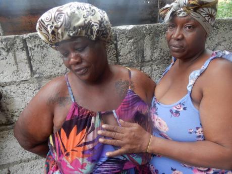 Credit: Romardo Lyons Alla-Kay Bartley (left), mother of the boys, being comforted by her mother, Winsome Beckford.