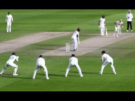 Credit: Michael Steele England’s Jos Buttler (left) prepares to take the catch to dismiss West Indies’ Kemar Roach (centre) during the third day of the third cricket Test match between England and West Indies at Old Trafford in Manchester, England, yesterday.