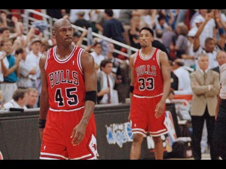 In this May 7, 1995 file photo, Chicago Bulls guard Michael Jordan (45) and forward Scottie Pippen (33) walk back to the bench during a time out in the closing seconds of an NBA basketball play-off game in Orlando. 