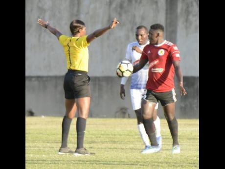 Referee Cardella Samuels (left) stands her ground over a decision to rule out a goal scored by Mount Pleasant FA’s Cardel Benbow during a Red Stripe Premier League match against hosts Portmore United at the Spanish Town Prison Oval last year January.