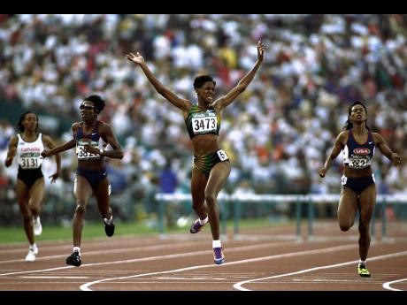 Deon Hemmings raises her arms aloft as she crosses the line to win the 400 metres hurdles final during the 1996 Olympic Games at the Olympic Stadium in Atlanta, Georgia, USA.