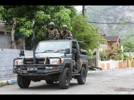 Soldiers patrol August Town after the community was designated a zone of special operations.