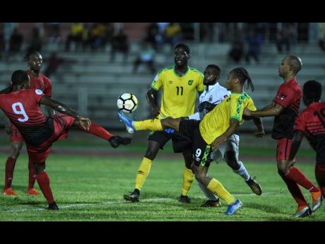 Jamaica’s Bobby Reid controls the ball ahead of Antigua’s Tevaughn Harriette in the Nations League match last year.