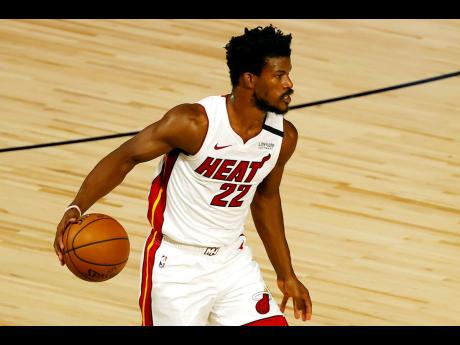 Miami Heat’s Jimmy Butler dribbles up court during the first half of an NBA basketball game against the Denver Nuggets, Saturday, August 1, 2020. 