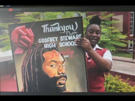 Jodiann Morris, female valedictorian of Godfrey Stewart High School’s Class of 2020, holds up a portrait of reggae artiste Buju Banton via Zoom.