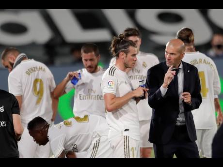 Real Madrid’s head coach Zinedine Zidane (right) talks with Real Madrid’s Gareth Bale during the Spanish La Liga match against Mallorca at the Alfredo di Stefano Stadium in Madrid, Spain, on Wednesday, June 24.