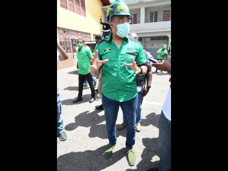 Prime Minister Andrew Holness, clad in green Clarks, addresses the media after he was nominated.