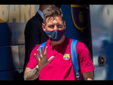 In this August 13, 2020 file photo, Barcelona’s Lionel Messi waves as he arrives at the team hotel in Lisbon, Portugal. 