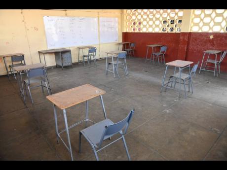 A sparsely furnished secondary school classroom.