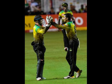 Glenn Phillips (left) and Mujeeb-ur-Rahman of Jamaica Tallawahs celebrate the dismissal of Darren Bravo of Trinbago Knight Riders.