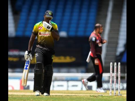 Nkrumah Bonner (left) of Jamaica Tallawahs walks off the field dismissed by Fawad Ahmed (right) of Trinbago Knight Riders during the Hero Caribbean Premier League semi-final between Jamaica Tallawahs and Trinbago Knight Riders at Brian Lara Cricket Academy yesterday in Tarouba, Trinidad and Tobago. The Knight Riders won by 9 wickets.