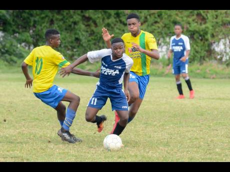File
In this file photo from August 2018, Cavalier FC’s Javon Smith (centre) slips by Santos FC’s Jean-Marc Gayle and drives towards the goal in their Kingston and St Andrew Football Association-sanctioned under-15 final.