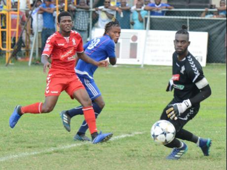 File
Amal Knight (right), goalkeeper from UWI FC, looks on as the ball rolls past the goalpost from a shot by Kemar Beckford (centre) from Mount Pleasant, during the second-leg semi-finals of the Red Stripe Premier League football.   
