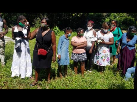 Mourners line up to get one look at Tamara Geddes in the coffin at the cemetery in Reserve, Trelawny.