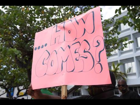 This placard was held aloft by a demonstrator during a protest on Trafalgar Road in Kingston in July 11 as persons sought answers about their high light bills. Complaints against the Jamaica Public Service Company have increased by196 per cent.