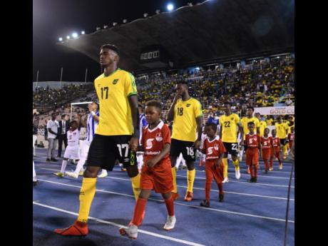FILE
Damion Lowe (left) leads the Reggae Boyz on to the field at the National Stadium last year to take on Honduras in a Concacaf Gold Cup match.