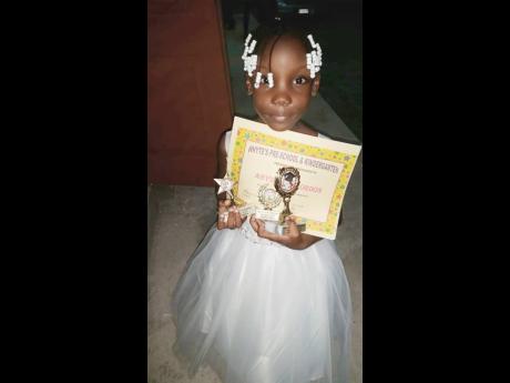 Seven-year-old Abysenya Gordon with her awards from the last prize- giving ceremony. 