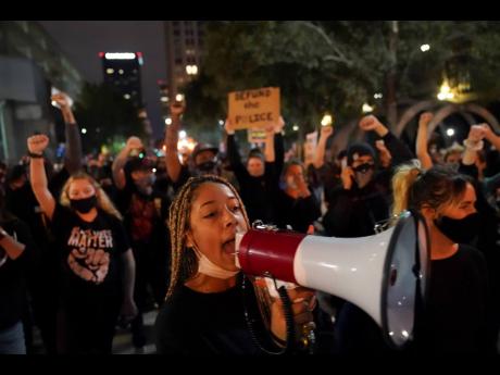 Protesters march on Thursday, in Louisville, Kentucky, USA. Authorities pleaded for calm while activists vowed to fight on in the state’s largest city, where a gunman wounded two police officers during protests following the decision not to charge officers for killing Breonna Taylor. 