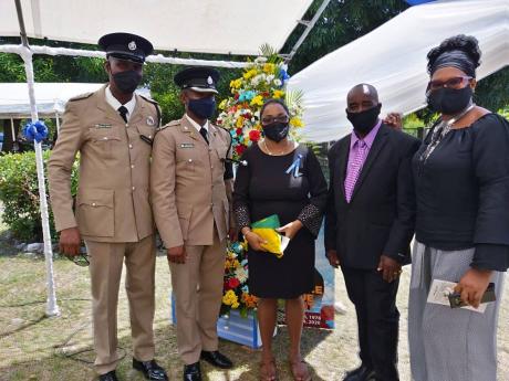 Kemoy Wright (centre) is supported by (from left) Deputy Superintendent Owen Brown, Superintendent Christopher Phillips, retired inspector Lynoval Ruddock, and Blanche Codnor of the Police Federation.