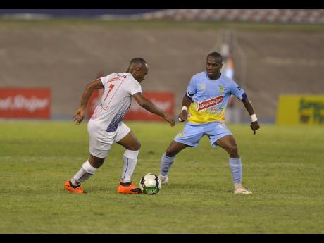 Portmore United’s Damian Williams moves away from Tramaine Stewart of Waterhouse in a Red Stripe Premier League encounter last year.