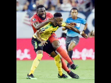 Jamaica’s forward Junior Flemmings (foreground) comes under a challenge from United States forward Jozy Altidore during a Concacaf Gold Cup semi-final match in Nashville, Tennessee, on July 3, 2019. 